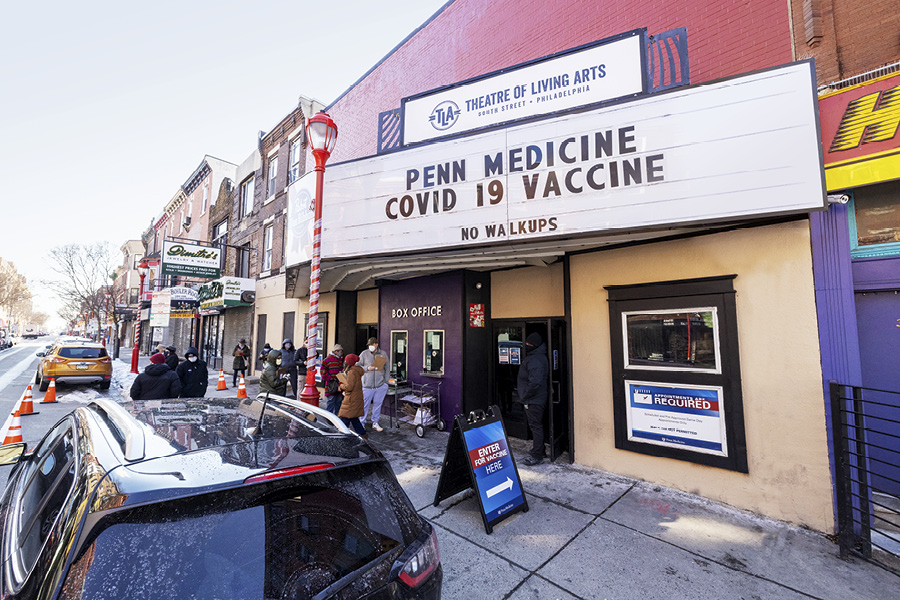 The marquee sign outside of the Theatre of the Living Arts in South Philadelphia reads: Penn Medicine COVID-19 Vaccine